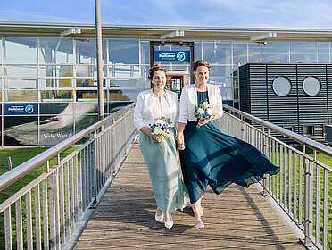 Ein fröhliches Hochzeitspaar vor dem Multimar Wattforum