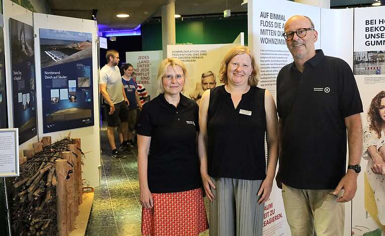 Drei Personen in einer Ausstellung